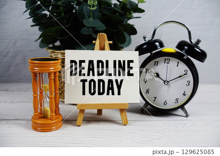 Deadline Today text with hourglass and alarm clock on wooden background 129625085