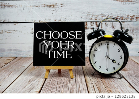 Choose Your Time text with easel and alarm clock on wooden background 129625138