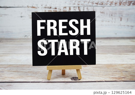 Fresh Start text with easel on wooden background Fresh Start text with easel on wooden background 129625164