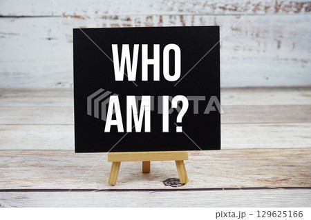 Who am I? text with easel on wooden background 129625166