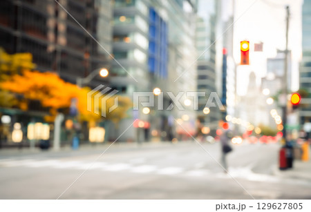 Blurred urban street scene with bokeh lights and colorful autumn trees with modern city buildings abstract background 129627805