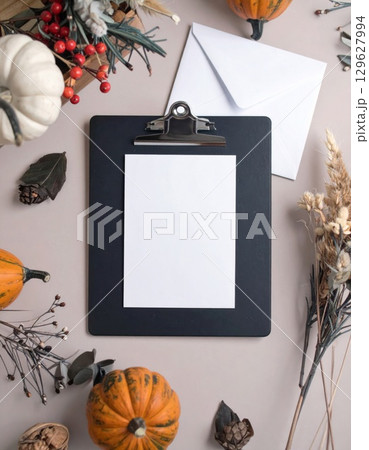 Autumn Harvest Still Life with Pumpkins and Stationary Items on Neutral Tabletop 129627994