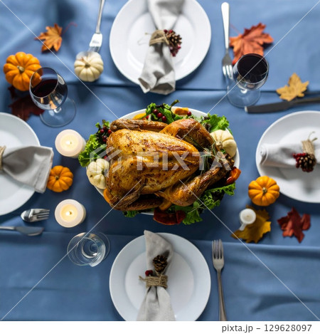 Festive Thanksgiving Table with Roasted Turkey and Autumn Decorations in Overhead Shot Festive Thanksgiving Table with Roasted Turkey and Autumn Decorations in Overhead Shot 129628097