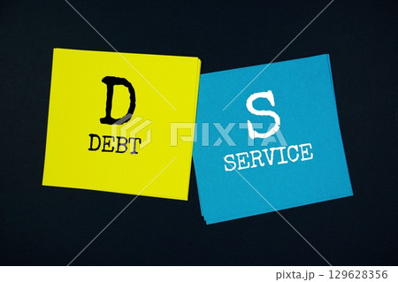 Debt Service (DS) text message on stick note on black background 129628356