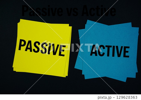 Passive vs Active text with sticky note on black background 129628363
