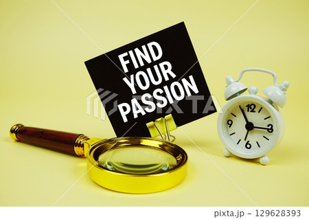 Find Your Passion text message on sticky note with magnifying glass and alarm clock on yellow background 129628393