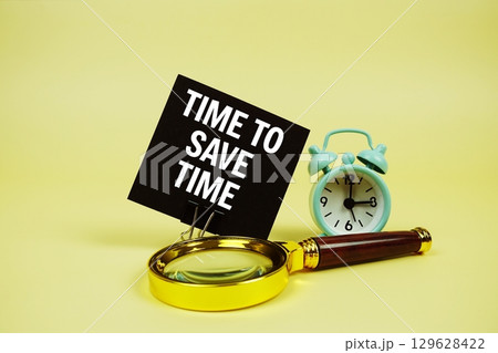 Time To Save Money text message on sticky note with magnifying glass and alarm clock on yellow background Time To Save Money text message on sticky note with magnifying glass and alarm clock on yellow background 129628422