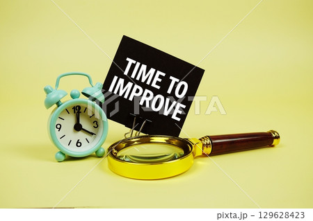 Time To Focus text message on sticky note with magnifying glass and alarm clock on yellow background 129628423