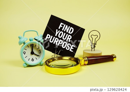 Find Your Purpose text message on sticky note with magnifying glass and alarm clock on yellow background Find Your Purpose text message on sticky note with magnifying glass and alarm clock on yellow background 129628424