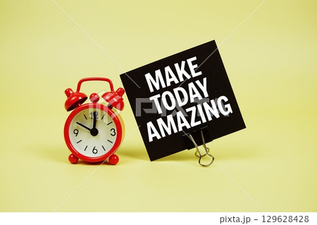 Make Today Amazing text message on paper card with alarm clock on yellow background Make Today Amazing text message on paper card with alarm clock on yellow background 129628428