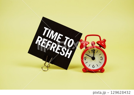 Time To Refresh text message on paper card with alarm clock on yellow background 129628432