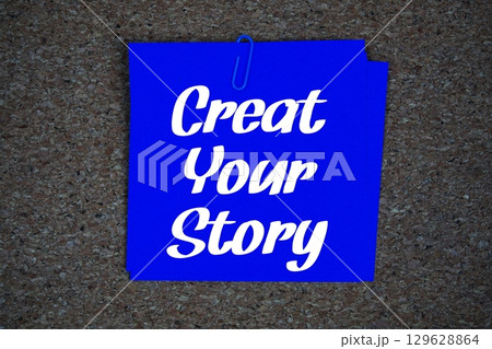 Create Your Story text message on stick note on cork paper background 129628864