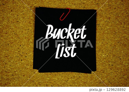Bucket List text message on sticky note on cork paper background 129628892