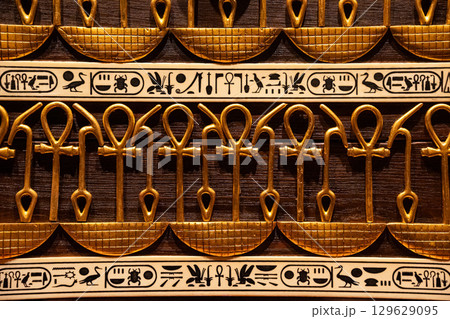 Ancient Egyptian hieroglyphs and ankh symbols gold relief detail,ornate patterns 129629095