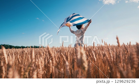 Patriot Boy Standing Wheat Field Holding Uruguayan Flag in the Wind, Uruguay Patriot Boy Standing Wheat Field Holding Uruguayan Flag in the Wind, Uruguay 129629236