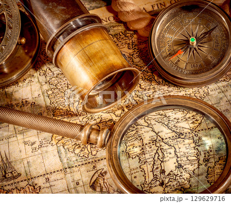 Vintage style travel and adventure. Vintage old compass and other vintage items on the table. Vintage style travel and adventure. Vintage old compass and other vintage items on the table. 129629716