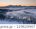 新潟県小千谷市　霧の流れる信濃川と朝焼けの越後三山の雪景色 129629907