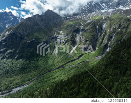 Aerial view of beautiful high altitude snow capped mountain and waterfall landscape 129630313