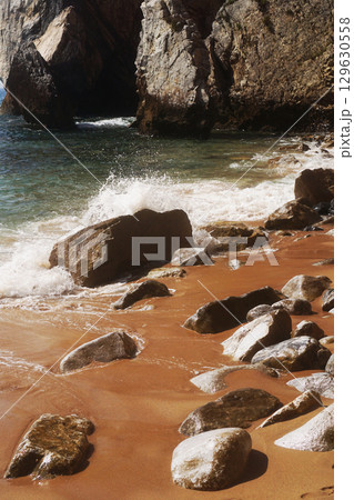 A Serene Beach Scene that Features Rocks and Gentle Waves on a Peaceful Summer Day A Serene Beach Scene that Features Rocks and Gentle Waves on a Peaceful Summer Day 129630558
