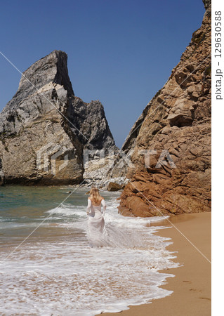 In Solitude by the Ocean A Woman Walking Alone Peacefully on the Beautiful Scenic Beachside In Solitude by the Ocean A Woman Walking Alone Peacefully on the Beautiful Scenic Beachside 129630588
