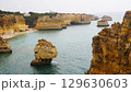 The coastal cliffs and stunning golden beach views create an unforgettable experience 129630603