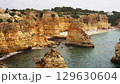 The coastal cliffs and stunning golden beach views create an unforgettable experience 129630604