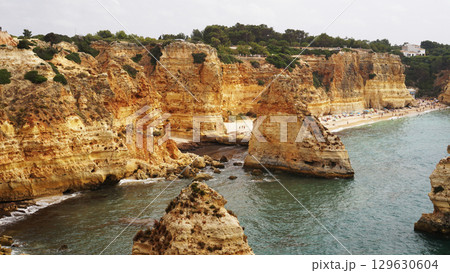 The coastal cliffs and stunning golden beach views create an unforgettable experience The coastal cliffs and stunning golden beach views create an unforgettable experience 129630604