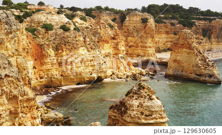 The coastal cliffs and stunning golden beach views create an unforgettable experience The coastal cliffs and stunning golden beach views create an unforgettable experience 129630605