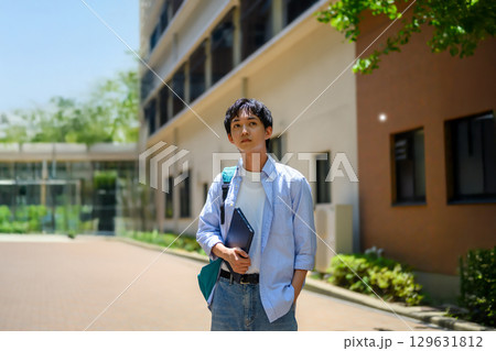 　キャンパスの外で立つ男子学生 129631812