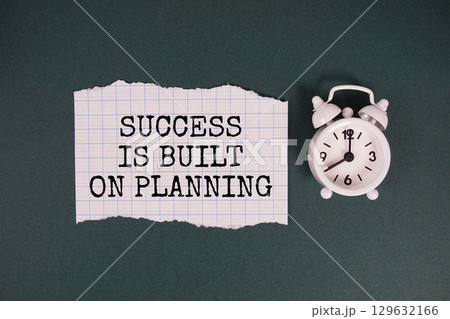 Success is Built on Planning text written on paper with alarm clock on green background 129632166