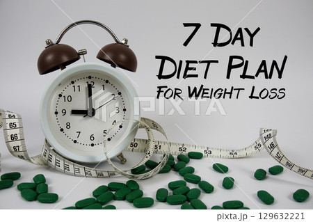 7 Day Diet Plan For Weight Loss text with medicine, alarm clock and measuring tape on white background 7 Day Diet Plan For Weight Loss text with medicine, alarm clock and measuring tape on white background 129632221
