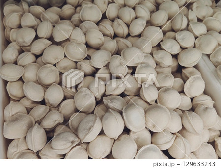 Raw dumplings with meat. dumplings with meat. frozen dumplings with meat. A lot of dumplings. 129633233