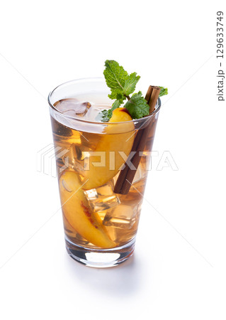 Refreshing peach iced tea in glass with ice cubes and cinnamon isolated on white background. Copy space Refreshing peach iced tea in glass with ice cubes and cinnamon isolated on white background. Copy space 129633749