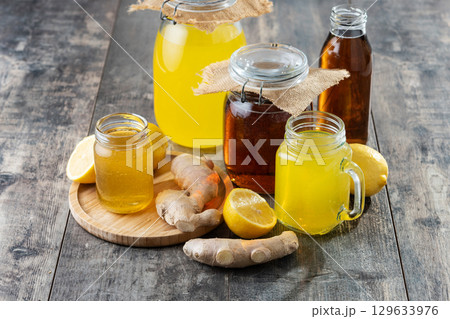 Colorful Kombucha Jars and Bottles on wooden table Colorful Kombucha Jars and Bottles on wooden table 129633976