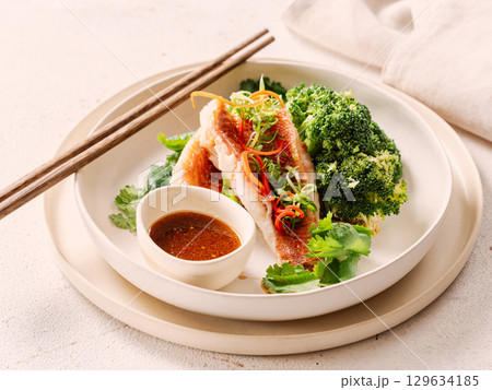 Captivating Capture: Exquisite Sea Bass with Broccoli in Asian style. Perfect Visual for Fish Food Menu Background. Delicious Baked Seabass with Broccoli And Sauce in Restaurant-style Plating 129634185