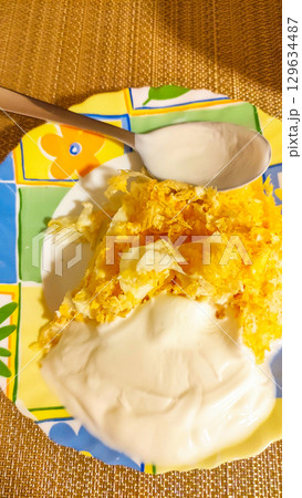 Scrambled eggs with yogurt and spices on colorful plate with spoon Scrambled eggs with yogurt and spices on colorful plate with spoon 129634487