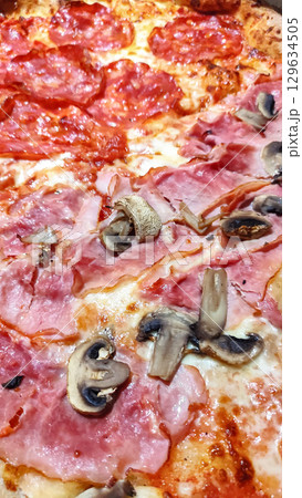 Delicious pizza with ham, mushrooms, and spicy salami baking in prague 129634505