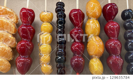 Chinese dessert Tanghulu made from crunchy caramelized fruit on a skewer. Sweet street food Chinese dessert Tanghulu made from crunchy caramelized fruit on a skewer. Sweet street food 129635784