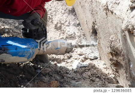 Workers are using a concrete hammer drill. Workers are using a concrete hammer drill. 129636085
