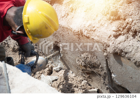 Workers are using a concrete hammer drill. Workers are using a concrete hammer drill. 129636104