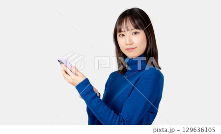 スマートフォンを持つ笑顔の女性・ビジネスウーマン スマートフォンを持つ笑顔の女性・ビジネスウーマン 129636105