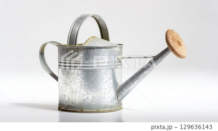 Rustic galvanized watering can with wooden handle isolated on white, ideal for farmhouse garden decor or heritage product visuals. Rustic galvanized watering can with wooden handle isolated on white, ideal for farmhouse garden decor or heritage product visuals. 129636143