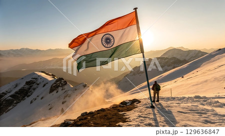 Indian flag waving atop snowy mountain peak with person standing nearby pole Indian flag waving atop snowy mountain peak with person standing nearby pole 129636847