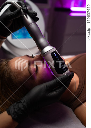 Professional endosphere therapy facial massage for skin tightening, rejuvenation, and anti aging in a modern spa clinic. 129637429