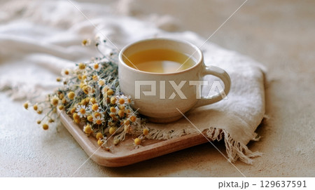 A peaceful wellness moment with tea, chamomile and natural materials captured in soft, earthy tones for lifestyle photography 129637591