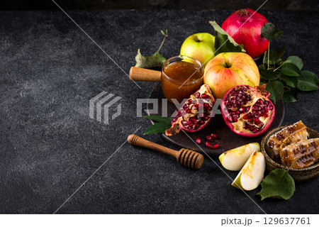 Rosh Hashana concept with honey, apple and pomegranate Rosh Hashana concept with honey, apple and pomegranate 129637761