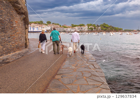 People walking dogs by the sea in Cadaques, Spain 129637834