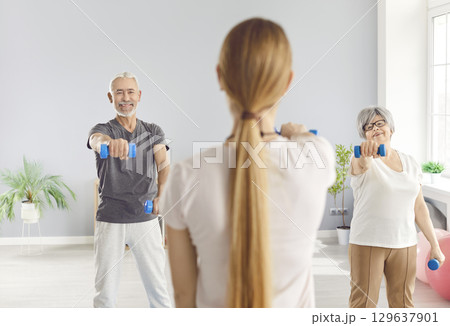 Senior health care rehabilitation with dumbbells and physical therapist, nurse or sport instructor 129637901