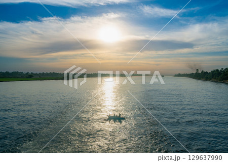 Sunset Over the Nile River Near Luxor With a small Boat. Sunset Over the Nile River Near Luxor With a small Boat. 129637990