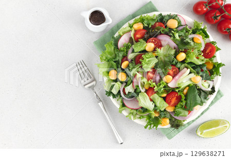 Summer green salad with tomatoes, redish and lupin beans on white background. Top view. Vegan food Summer green salad with tomatoes, redish and lupin beans on white background. Top view. Vegan food 129638271